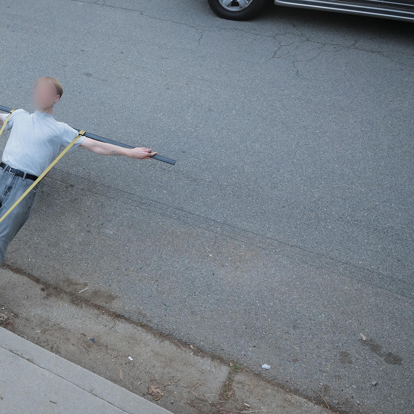 Corbin — Crisis Kid, street diptych (2 of 2): the figure leaning back, outstretched arm holding the bar