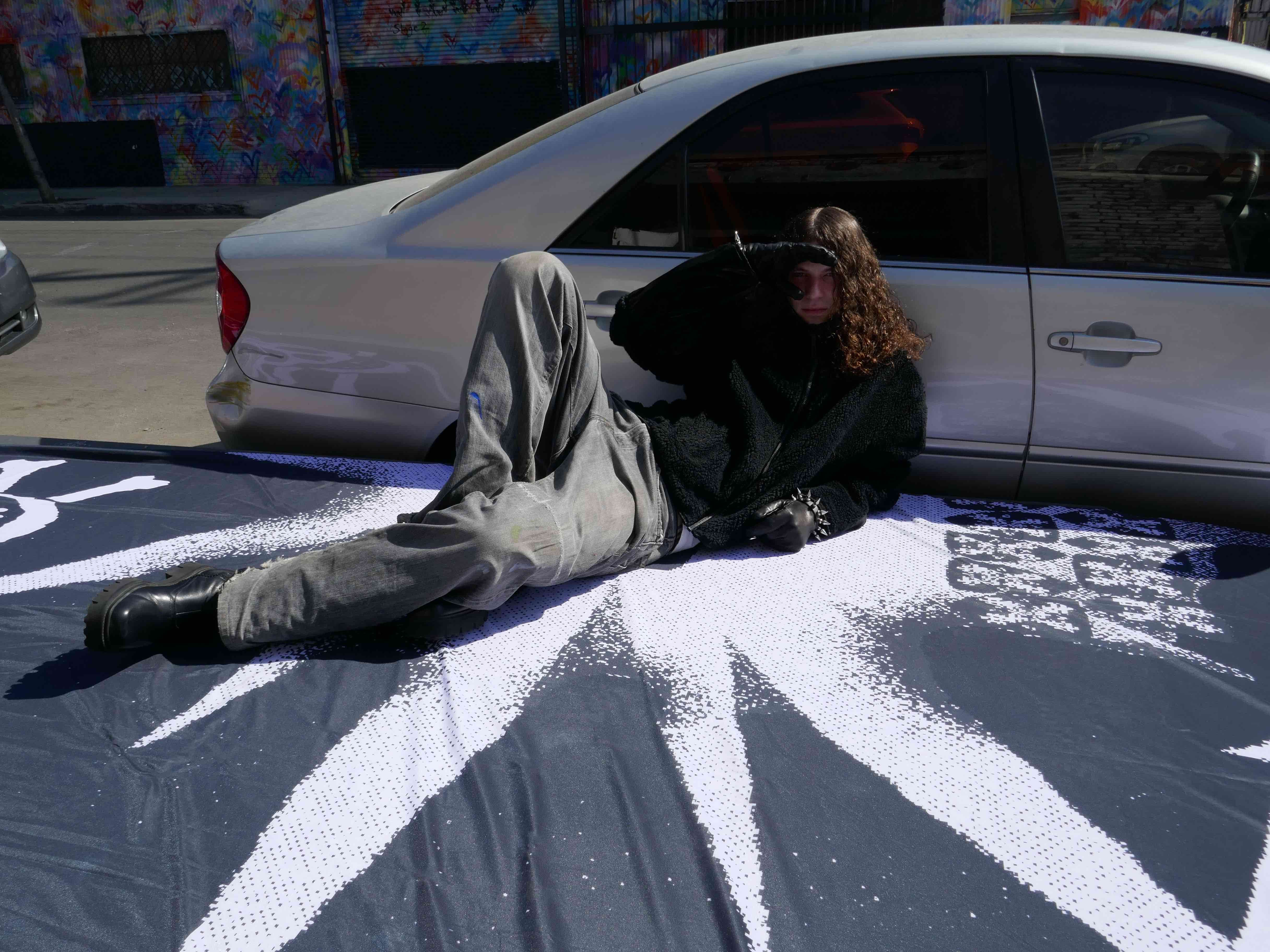 032c × Drain Gang — reclining by the car on painted asphalt