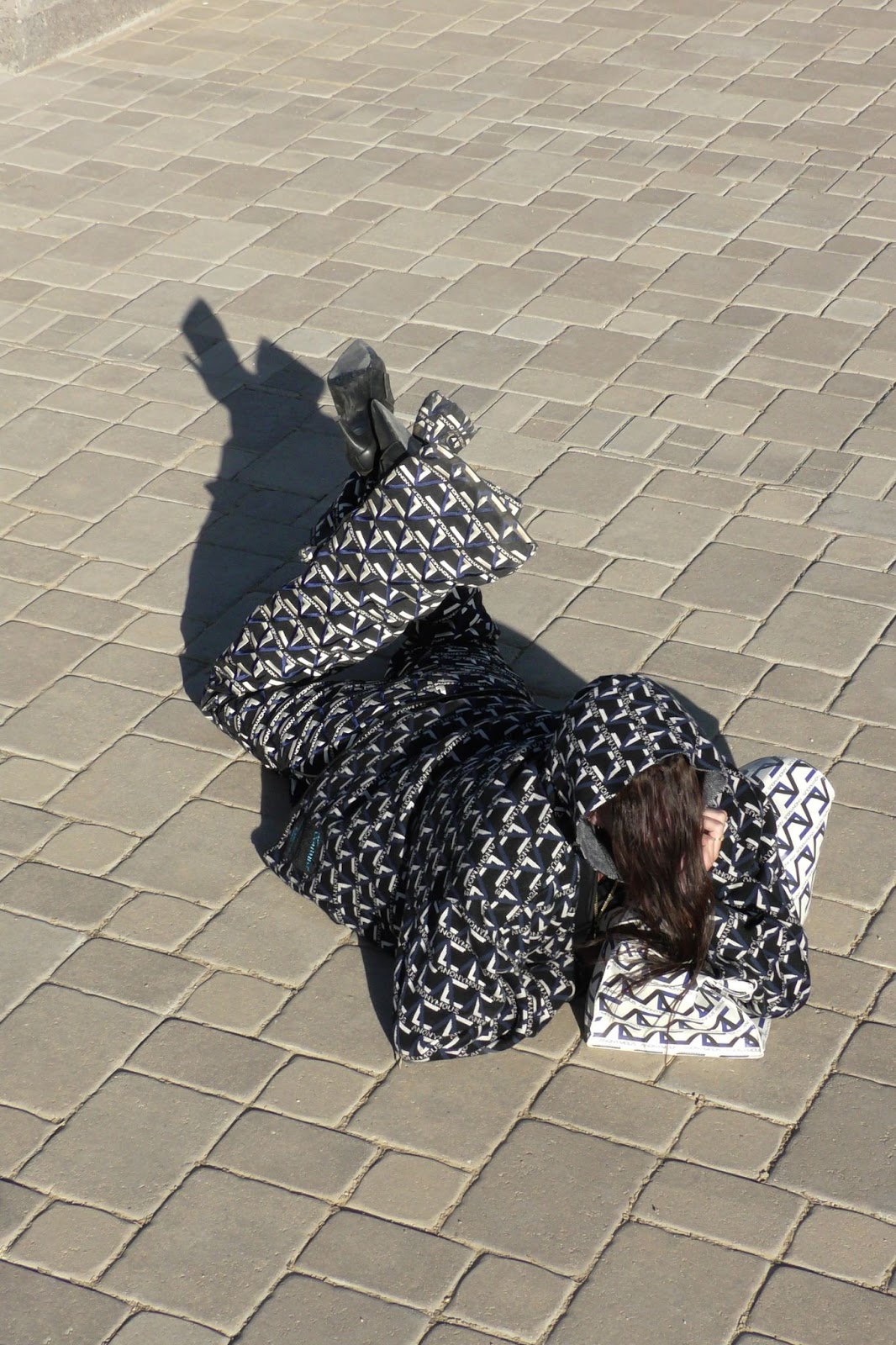 Hood By Air — Trust Exercise, figure lying on the paving in a monogram outfit
