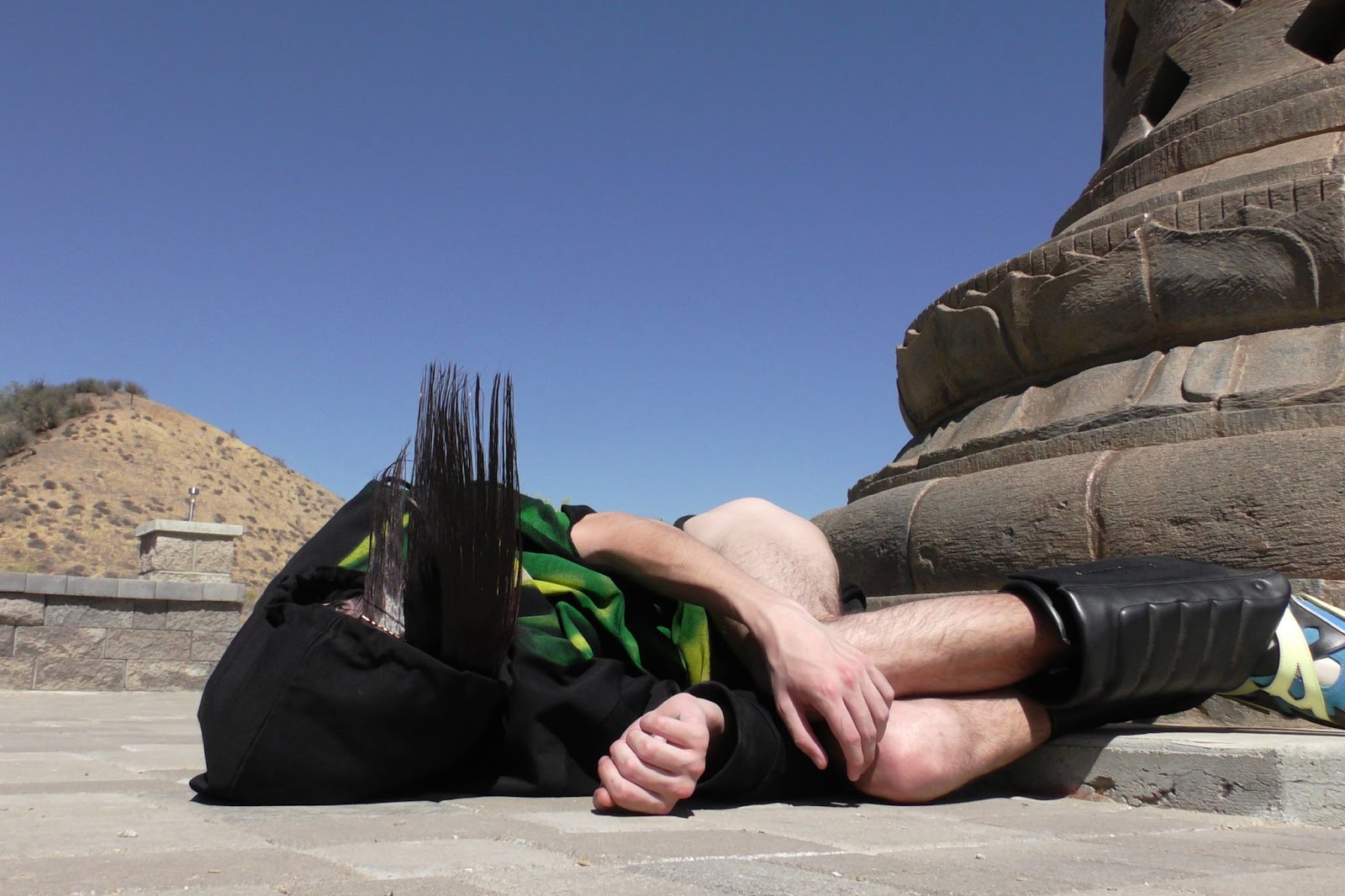 Hood By Air — Trust Exercise, figure lying at the base of the monument