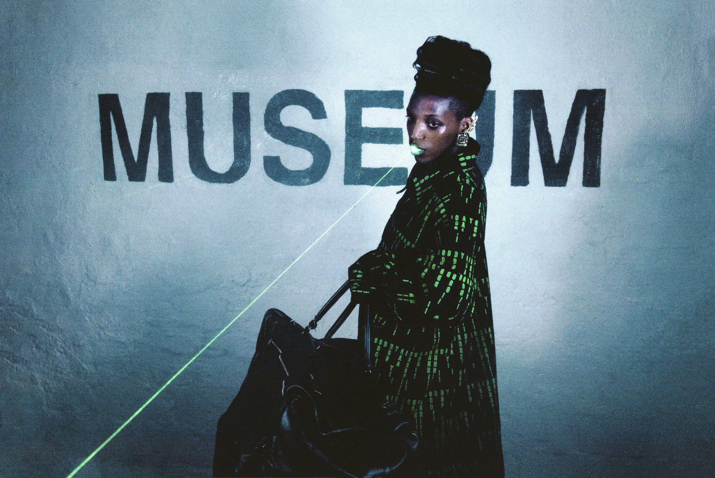 Hood By Air — Museum, model in a green-code coat in profile, with a laser beam