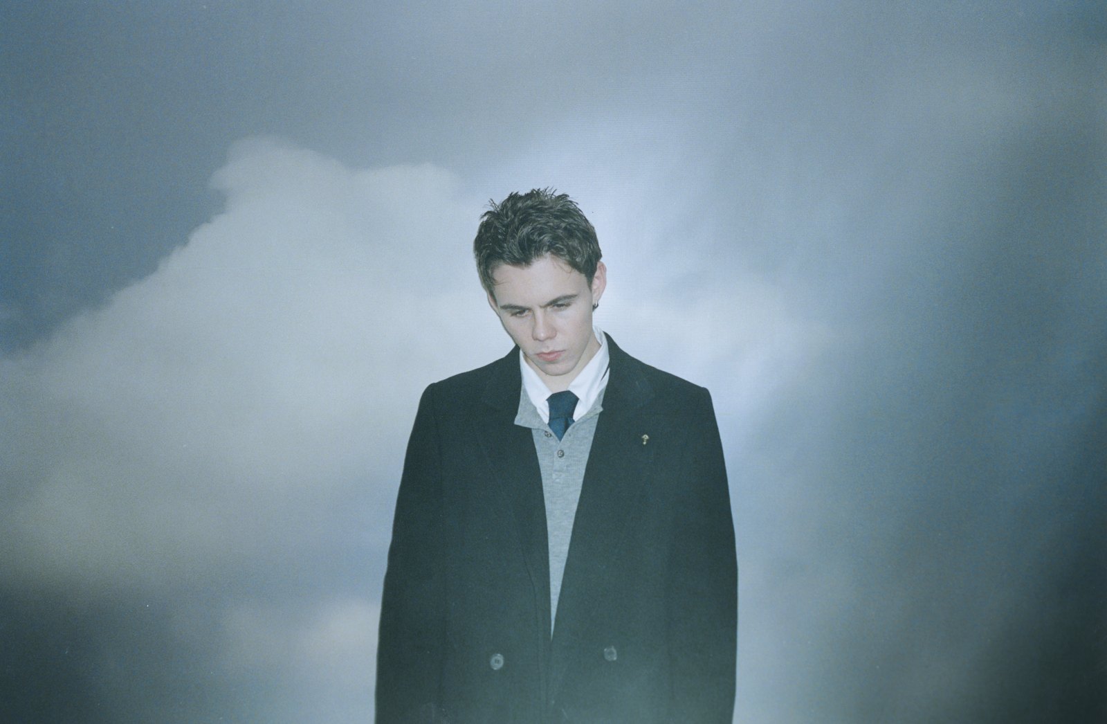 The Kid Laroi portrait in a suit against clouds