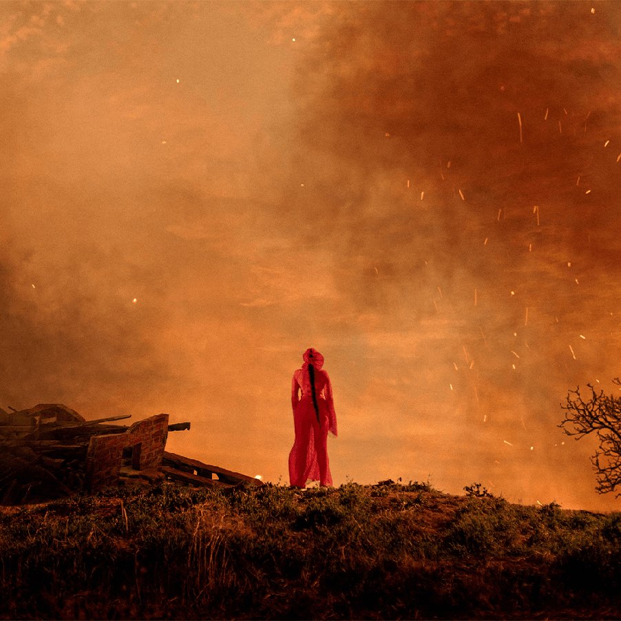 Noah Cyrus — figure on a hill under an orange sky